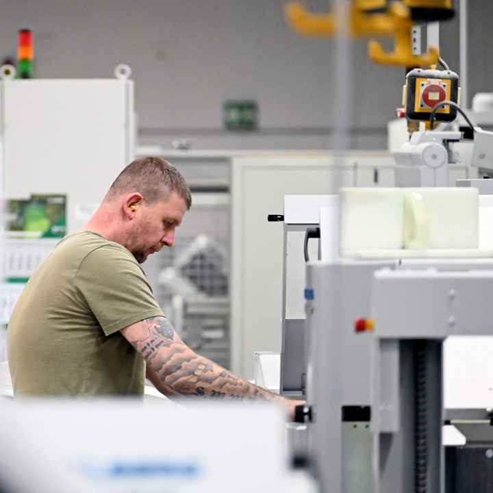 Mitarbeitender an Maschine