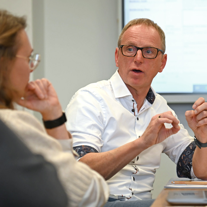 Mitarbeitende im Gespräch am Tisch